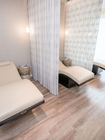 Entspannungsbereich im Spa mit bequemen Liegen und Vorhängen