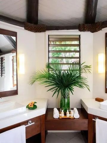 Modernes Badezimmer mit Doppelwaschbecken und frischen Pflanzen.