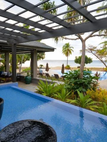 Ausblick vom Infinity-Pool mit Garten und Meerblick im Hintergrund.