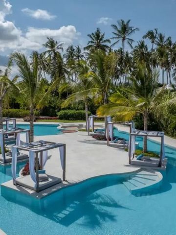 Infinity Pool umgeben von Palmen und luxuriösen Baldachinen