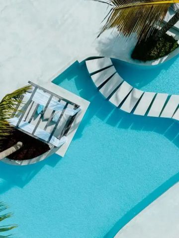 Pool mit geschwungenen Formen und Palmen im Hintergrund