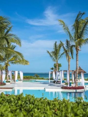 Luxuriöser Poolbereich mit Meerblick und tropischen Pflanzen