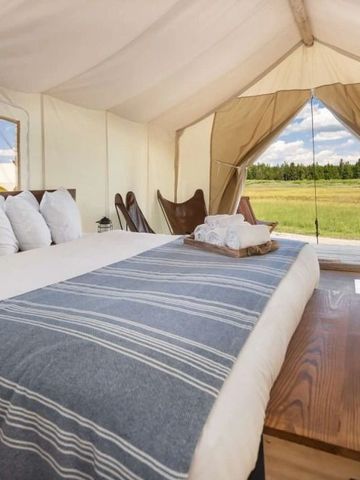Helles Zeltzimmer mit Blick auf eine grüne Landschaft