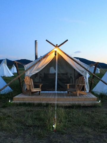 Beleuchteter Zelteingang bei Dämmerung im Naturschutzgebiet