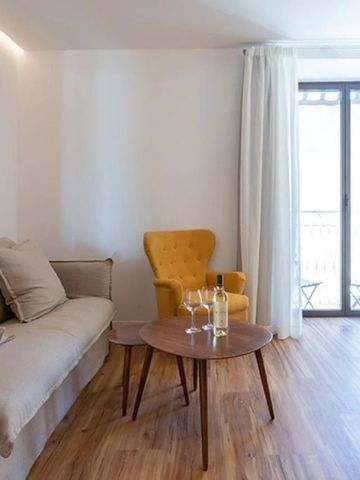 Helles Wohnzimmer mit bequemer Couch, gelbem Sessel und Holztisch