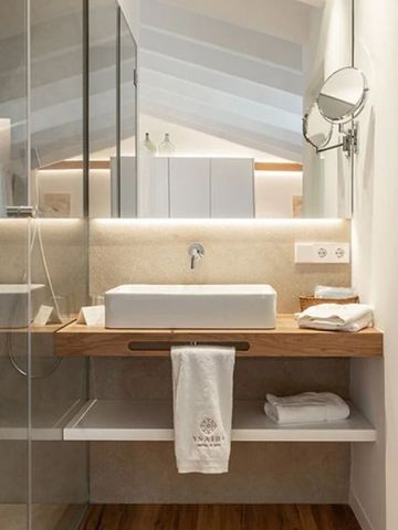 Badezimmer mit großem Spiegel und stilvollem Waschbeckenbereich