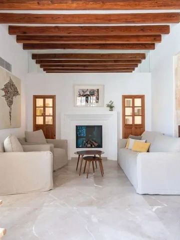 Heller Loungebereich mit Holzbalkendecke und zwei Sofas um einen modernen Kamin