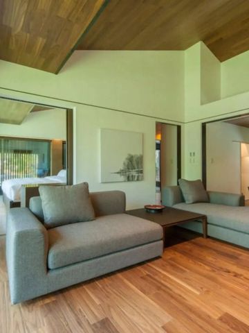 Geräumiges Wohnzimmer mit bequemen Sofas und Holzelementen.