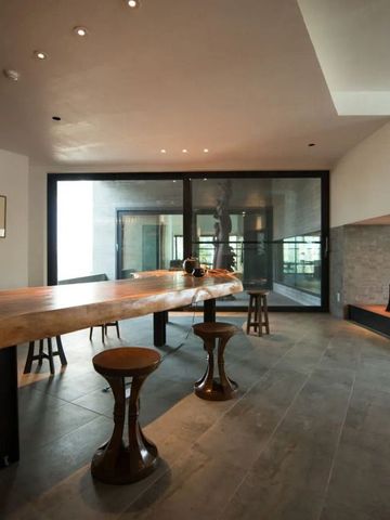 Eleganter Gemeinschaftsraum mit modernem Holztisch und Hockern im Zaborin Ryokan.