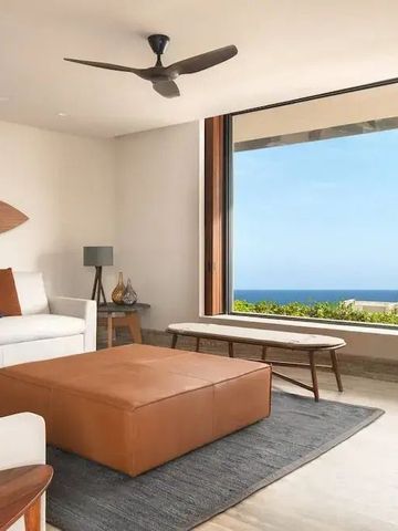 Wohnbereich einer Suite mit großem Fenster und Meeresblick