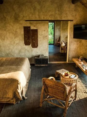 Helles Schlafzimmer mit Doppelbett und gemütlicher Sitzecke