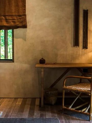 Stilvoll eingerichtetes Hotelzimmer mit Schreibtisch und Korbstuhl