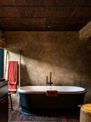 Luxuriöses Badezimmer mit freistehender Badewanne und gedämpfter Beleuchtung