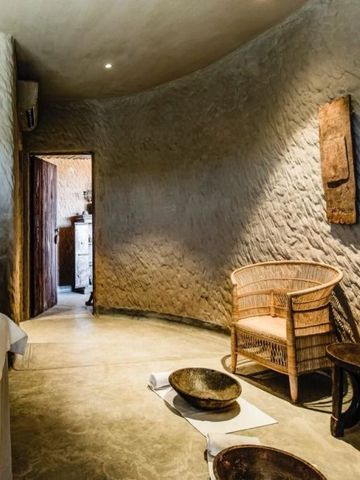 Helles Zimmer mit elegantem weißen Bett und rustikalen Holzakzenten.