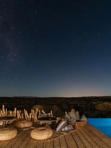 Infinity Pool unter sternenklarem Nachthimmel mit weiten Aussichten.