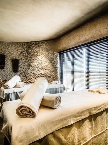 Zwei Massageliegen in einem stilvollen Spa-Raum mit großen Fenstern.