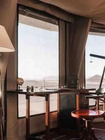 Schreibtisch mit Fernrohr und Lampe in Zelt mit Aussicht