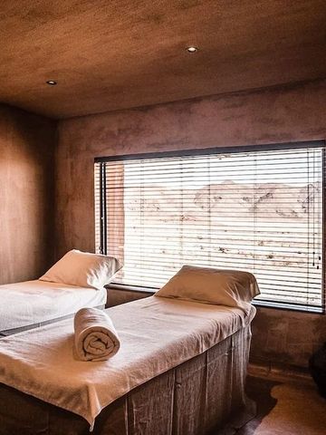 Spa-Behandlungsraum mit Liegen und Blick in die Natur