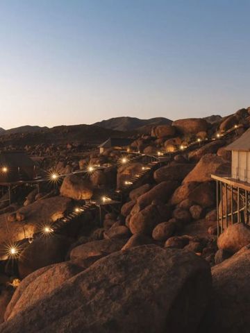 Luxuriöse Zelte auf Felsen in der Wüste bei Sonnenuntergang