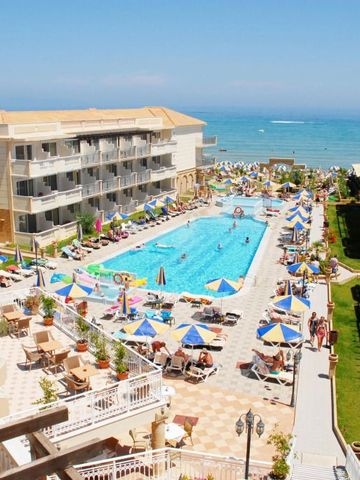 Blick auf den Hauptpool des Hotels mit Liegen und Sonnenschirmen sowie Meerblick.