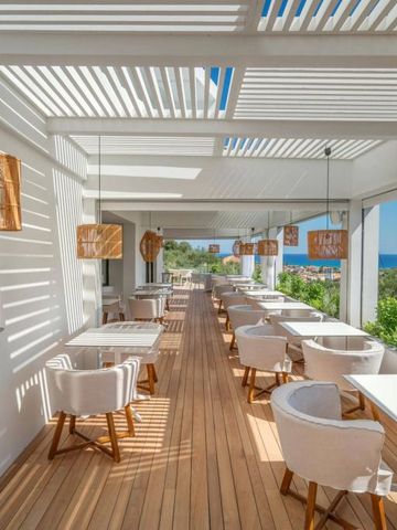 Helles Restaurant mit Holzboden und eleganten Lampen auf einer überdachten Terrasse.