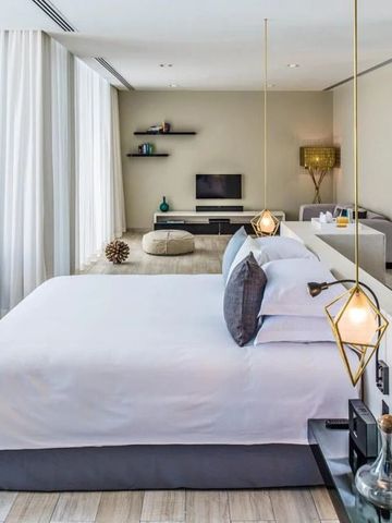 Elegantes, helles Zimmer mit großem Bett und modernen Lampen