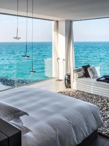 Luxuriöses Schlafzimmer mit großem Fenster und Meerblick