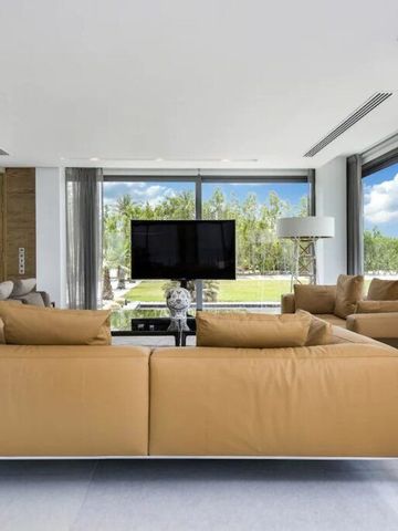 Stilvolles Wohnzimmer mit braunen Sofas und großen Fenstern in einer Villa