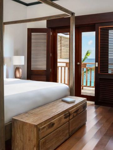 Hotelzimmer mit Himmelbett und Balkon mit Meerblick