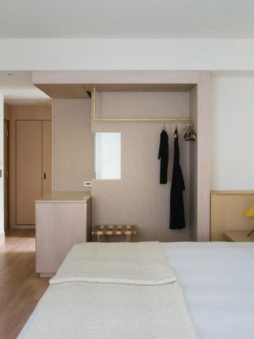 Helles Hotelzimmer mit kleinem Kleiderschrank und minimalistischem Design