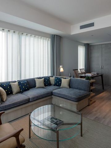 Modern eingerichtetes Hotelzimmer mit eleganter Sitzecke und großen Fenstern