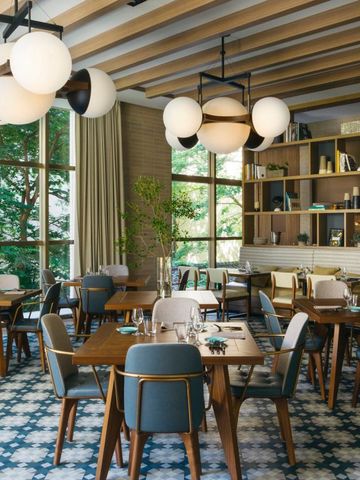 Helles Hotelrestaurant mit modernen Möbeln und einem Blick auf den Garten