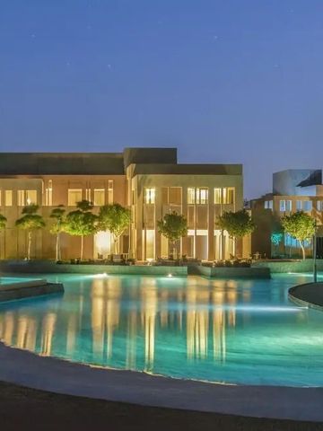 Beleuchtete Hotelanlage bei Nacht mit Poollandschaft