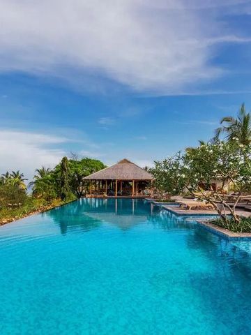 Infinity Pool mit Palmen und Hütte im Hintergrund