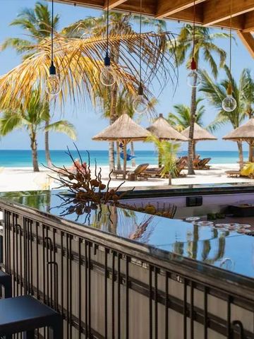 Bar mit Blick aufs Meer und Palmen im Hintergrund