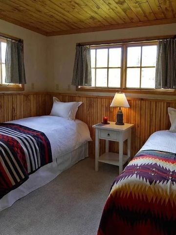 Zweibettzimmer mit Holzwänden und farbenfrohen Decken