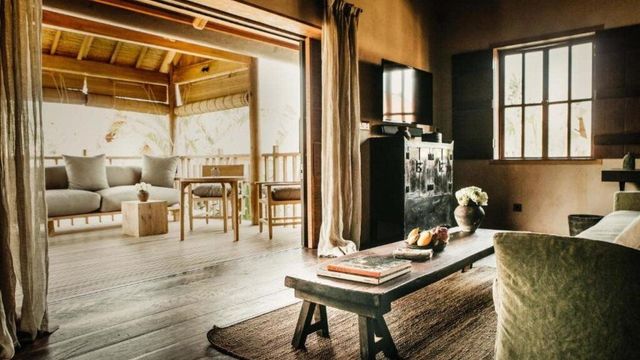 Rustikales Wohnzimmer mit offenem Balkon und Holzbalken