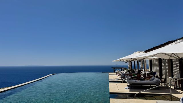 Infinity-Pool im Freien mit Blick auf das endlose blaue Meer unter strahlendem Himmel