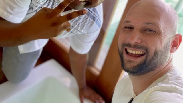 Zwei Männer lächeln in die Kamera neben einer luxuriösen Badewanne