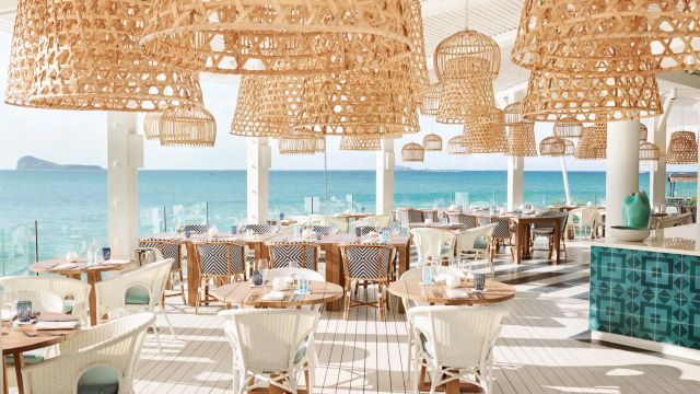 Restaurant mit Korblampen und Meeresblick auf einer Terrasse am Strand