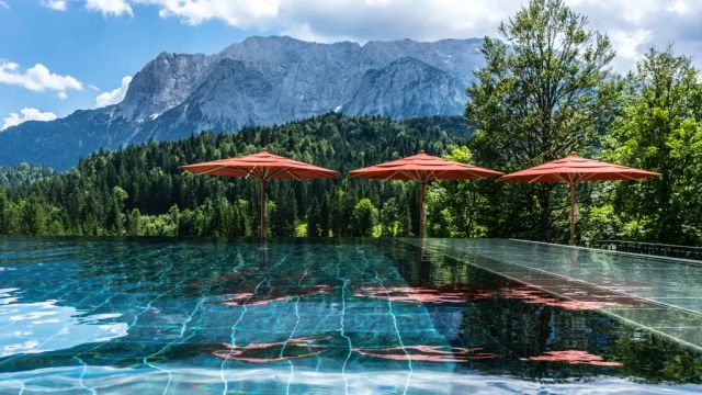 Schloss Elmau Pool mit Liegestühlen und Sonnenschirmen