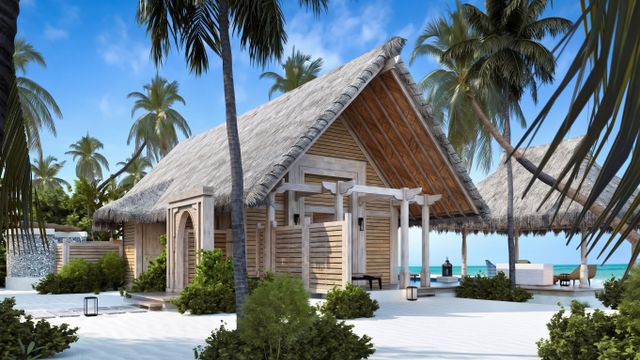 Strandvilla aus Holz mit Reetdach umgeben von Sand und Palmen am blauen Meer.