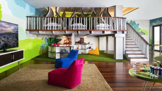 Kinderzimmer mit bunten Sitzkissen und Spielbereich unter Zwischengeschoss