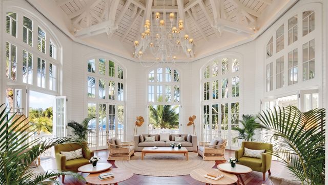 Helle und elegante Hotel-Lobby mit hohen Fenstern und edlem Kronleuchter.