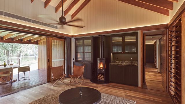 Gemütlicher Wohnbereich mit Holzboden, Kamin und großer Glasfront