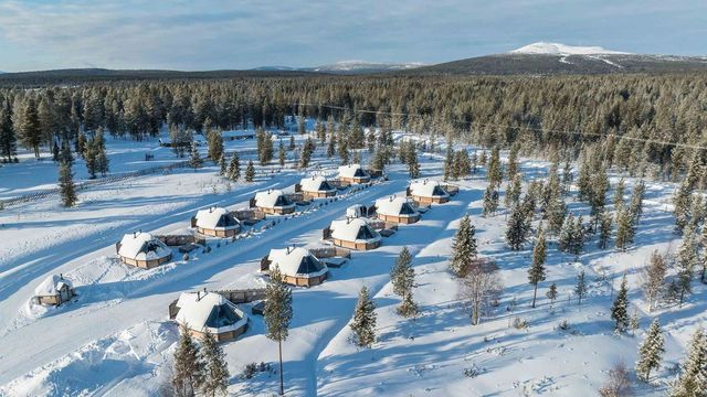 Luftbild der Glasiglus von Reindeer Manor in einer verschneiten Waldlichtung bei Levi in Lappland