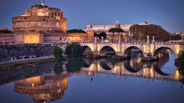 Castel Sant'Angelo und Brücke reflektieren im ruhigen Fluss bei Abenddämmerung