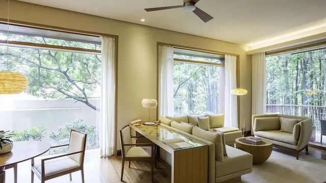 Geräumiges Wohnzimmer mit großen Fenstern und modernen Möbeln