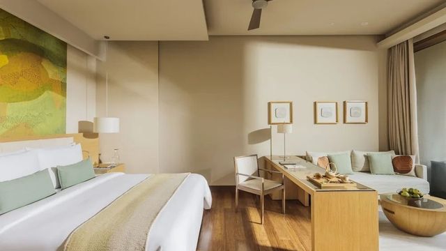 Helles Schlafzimmer mit Doppelbett und gemütlichem Sitzbereich