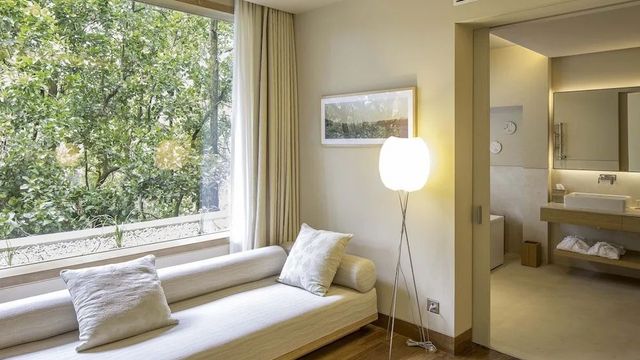 Gemütlicher Wohnbereich mit Tagesbett und Blick auf den grünen Garten